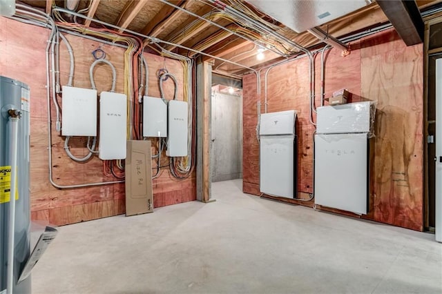 basement featuring water heater and white refrigerator