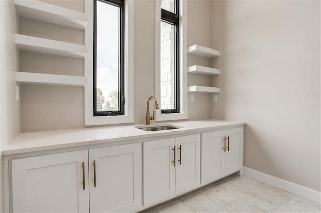 3411 S Mize Ridge Ct, Independence, MO 64057 - bar featuring a sink, baseboards, and light marble finish floors