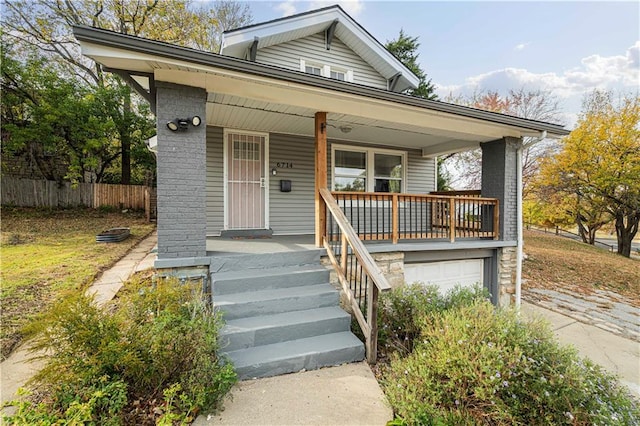 bungalow-style house featuring covered porch and a garage