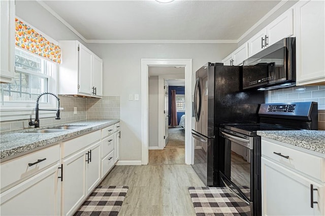 kitchen featuring sink, electric range, light stone counters, and white cabinets