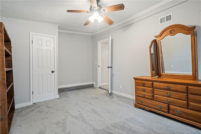 unfurnished bedroom featuring light carpet, crown molding, a textured ceiling, and ceiling fan