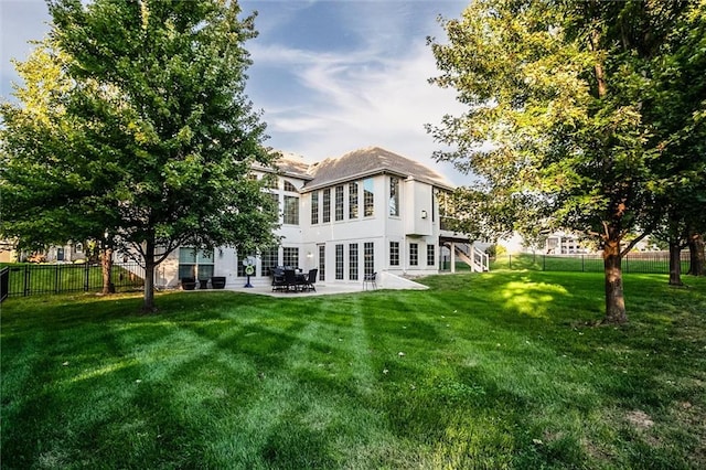 rear view of property featuring a yard and a patio area
