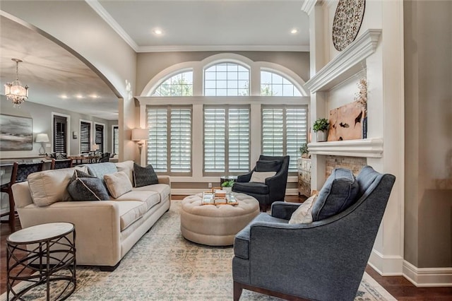 living room featuring a chandelier, wood-type flooring, and ornamental molding