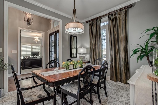 dining area with light hardwood / wood-style flooring, a chandelier, and crown molding