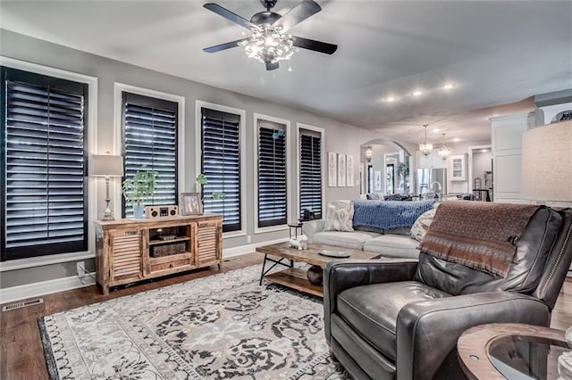 living room featuring ceiling fan with notable chandelier and wood-type flooring