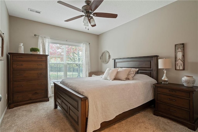carpeted bedroom with ceiling fan and a textured ceiling