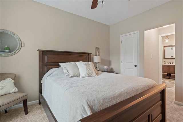 bedroom with light carpet, ceiling fan, and ensuite bath
