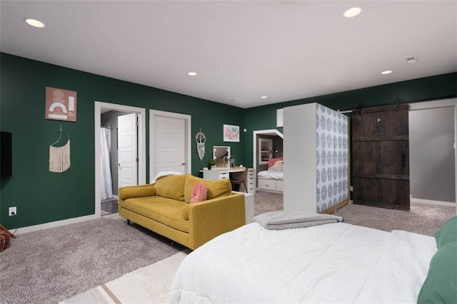 bedroom with light carpet and a barn door