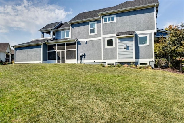 rear view of property featuring a lawn and a sunroom