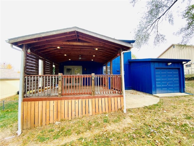 view of front facade with a wooden deck, an outbuilding, and a garage