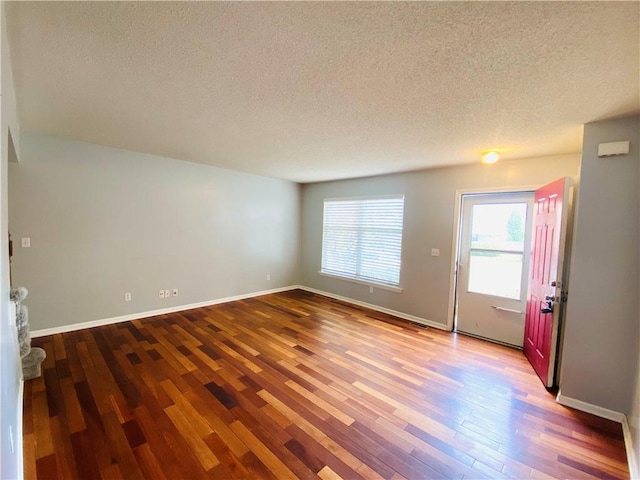 unfurnished room featuring a textured ceiling and wood-type flooring