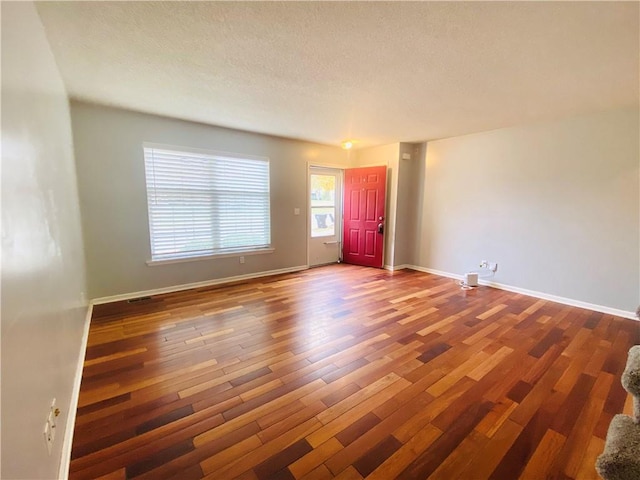 unfurnished room featuring a textured ceiling and hardwood / wood-style flooring