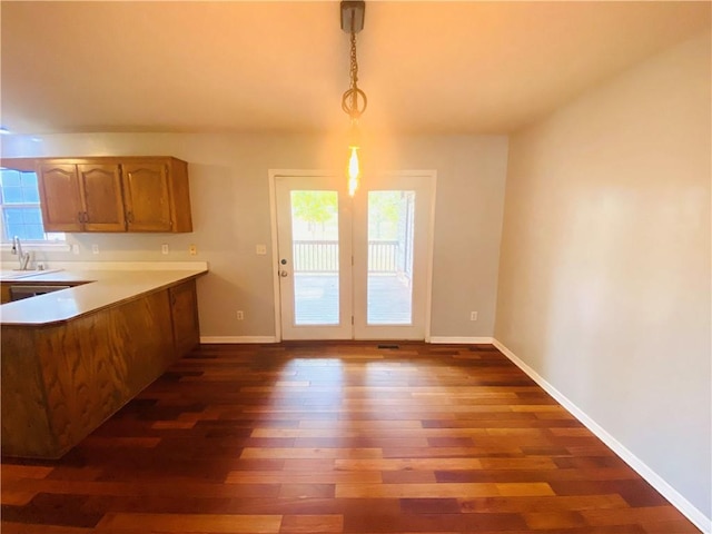 kitchen with dark hardwood / wood-style flooring, a healthy amount of sunlight, sink, and pendant lighting