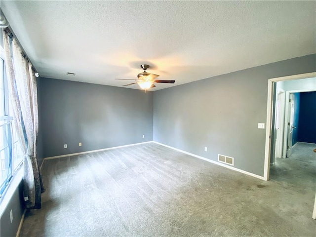 carpeted empty room with a textured ceiling and ceiling fan