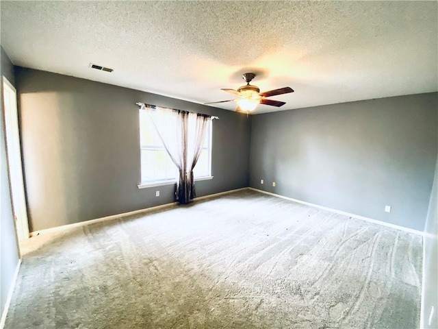 spare room with carpet, a textured ceiling, and ceiling fan