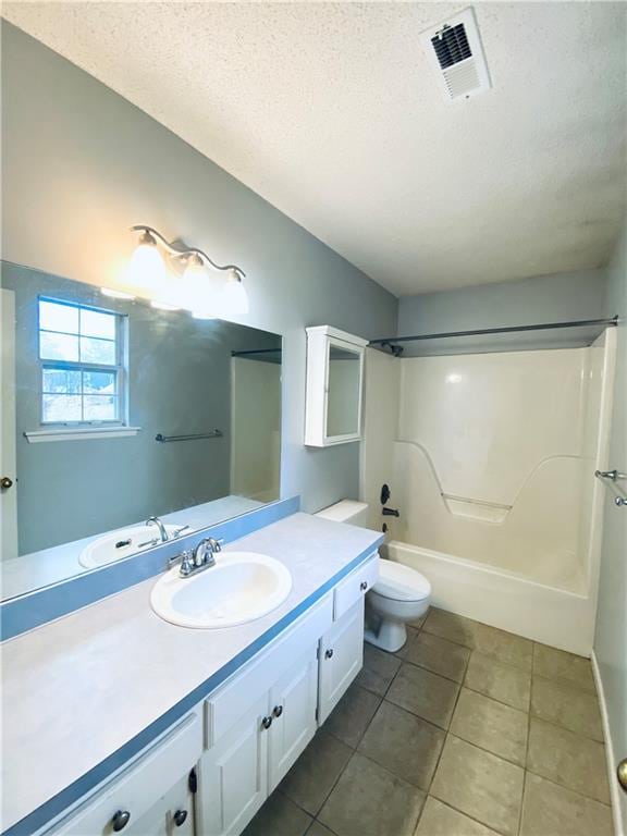 full bathroom featuring  shower combination, a textured ceiling, toilet, tile patterned floors, and vanity