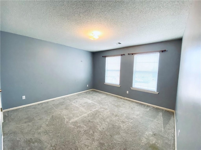 carpeted spare room with a textured ceiling