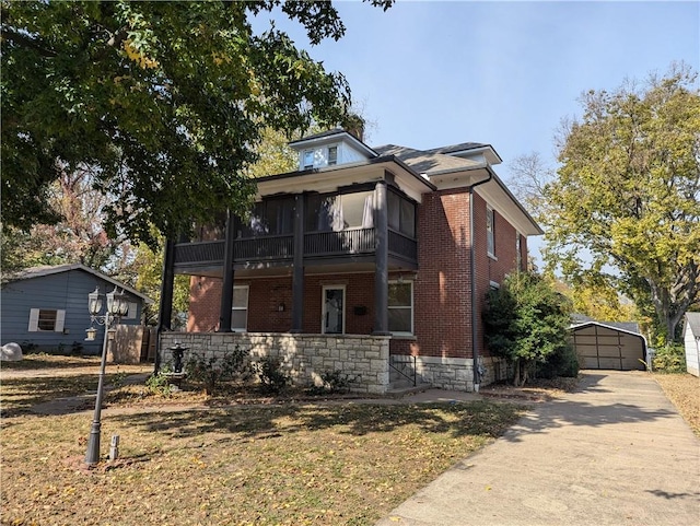 612 W Cherry St, Nevada, MO 64772 - view of front of home featuring brick siding, an outbuilding, a garage, a balcony, and a front yard