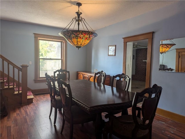 612 W Cherry St, Nevada, MO 64772 - dining area featuring dark wood finished floors, stairs, and a textured ceiling