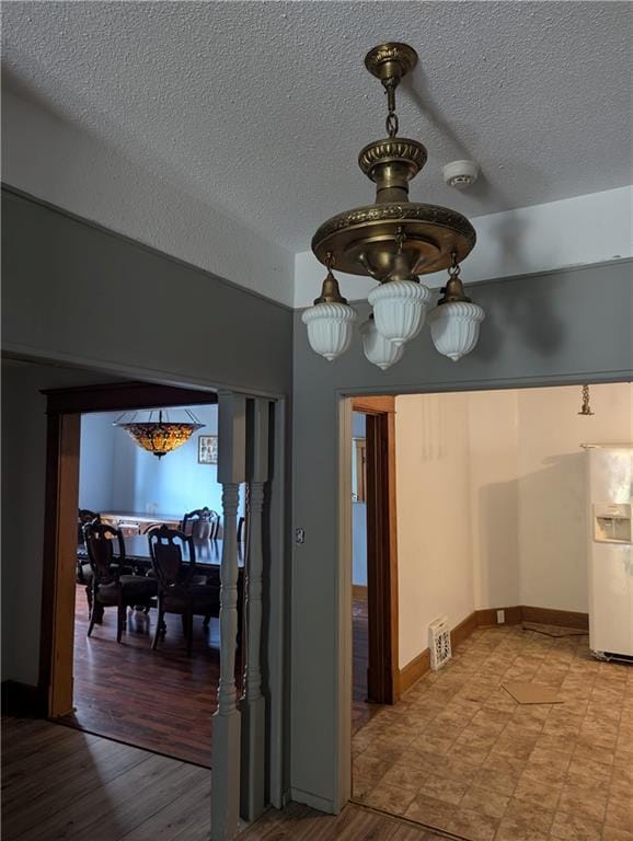 612 W Cherry St, Nevada, MO 64772 - hallway featuring a textured ceiling, wood finished floors, and baseboards