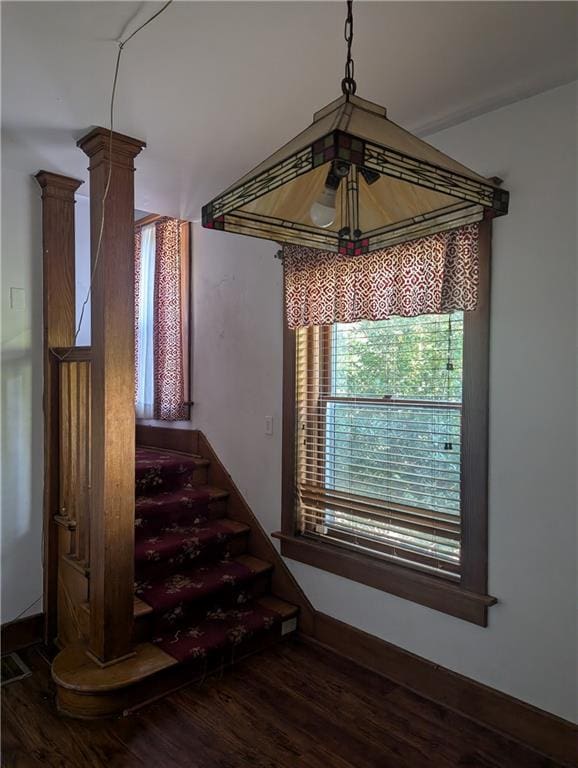 staircase with hardwood / wood-style floors and ornate columns