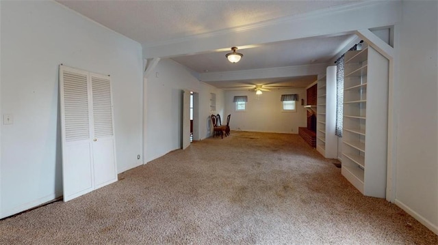 carpeted spare room with beam ceiling and ceiling fan