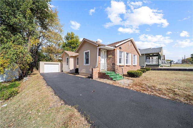 view of front facade featuring a front yard, a garage, and an outdoor structure