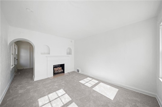 unfurnished living room featuring light colored carpet