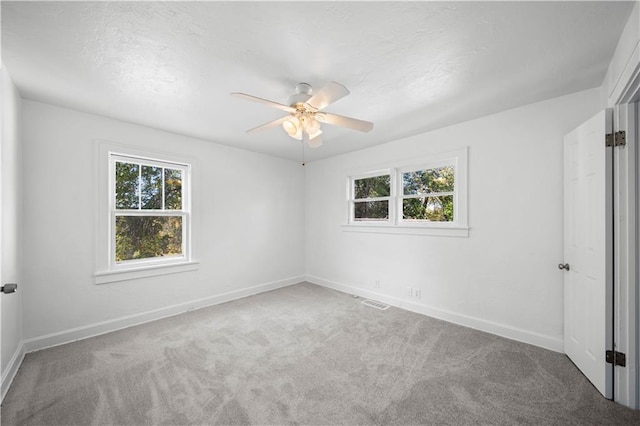 spare room featuring ceiling fan, carpet flooring, and a textured ceiling