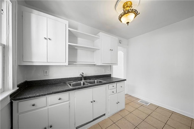 kitchen with sink, white cabinetry, and light tile patterned flooring