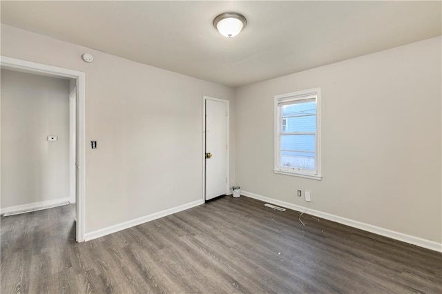 spare room with dark wood-type flooring