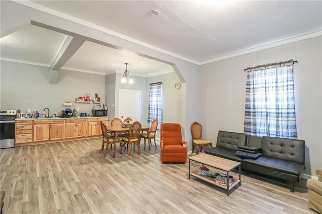 living room with sink, crown molding, a notable chandelier, and light hardwood / wood-style flooring