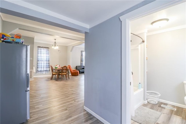 interior space with ornamental molding, a chandelier, and hardwood / wood-style floors