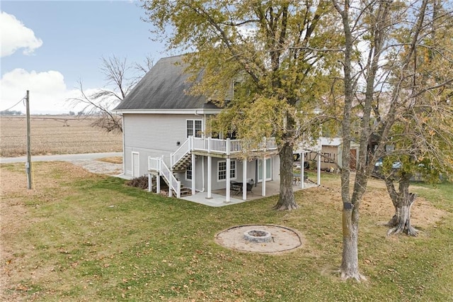 rear view of property with a wooden deck, a yard, and a patio