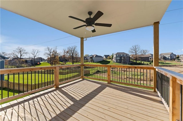 wooden deck with a lawn and ceiling fan