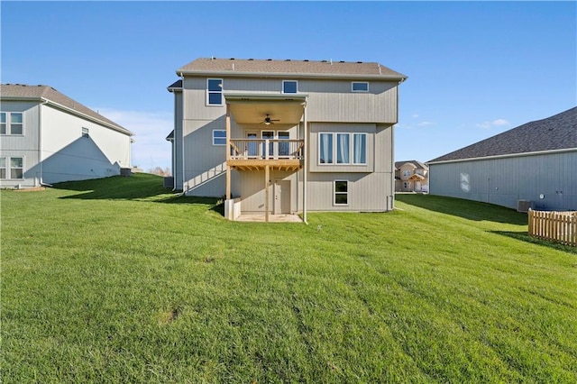 rear view of house with a wooden deck, a yard, and ceiling fan