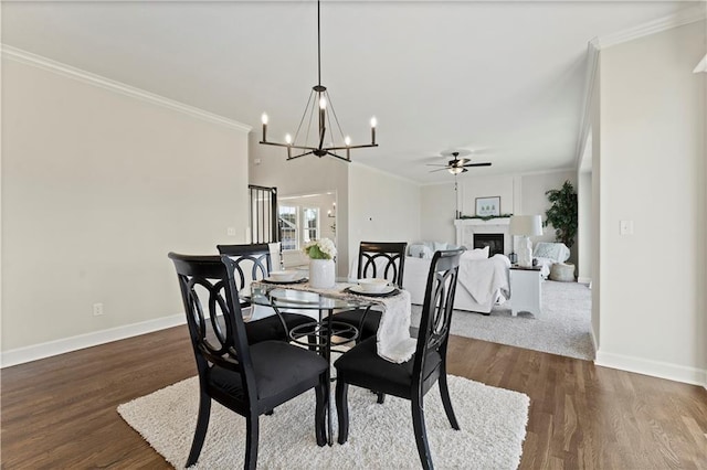 dining space with ceiling fan with notable chandelier, crown molding, and dark hardwood / wood-style flooring