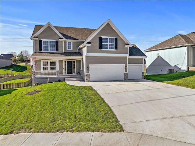 view of front of home featuring covered porch, a front lawn, a garage, and central AC unit