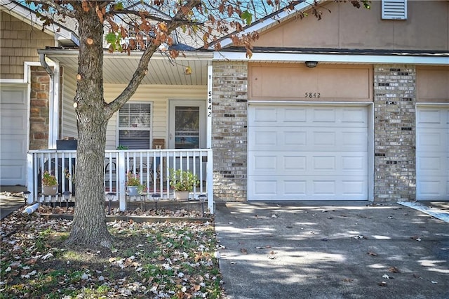 entrance to property with a garage and covered porch