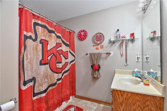 bathroom featuring walk in shower, vanity, a textured ceiling, and tile patterned floors