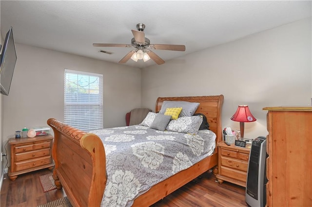 bedroom featuring dark wood-type flooring, ceiling fan, and heating unit