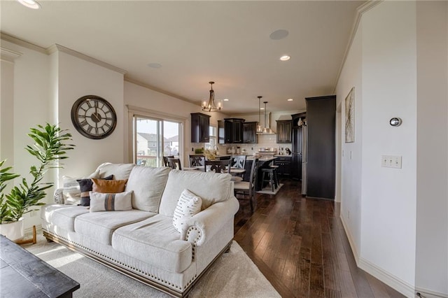 living room featuring dark hardwood / wood-style floors, crown molding, and a notable chandelier