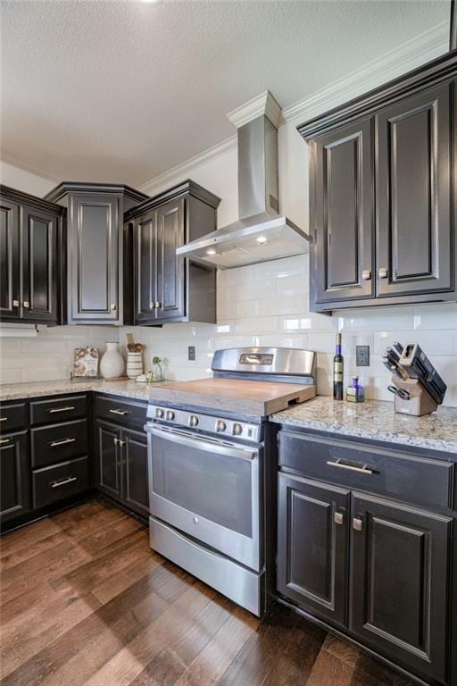 kitchen featuring backsplash, stainless steel electric stove, crown molding, dark wood-type flooring, and wall chimney range hood