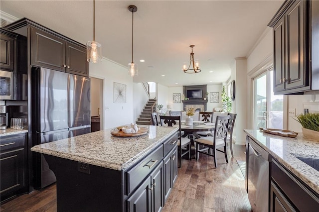 kitchen with crown molding, appliances with stainless steel finishes, dark hardwood / wood-style floors, and a center island