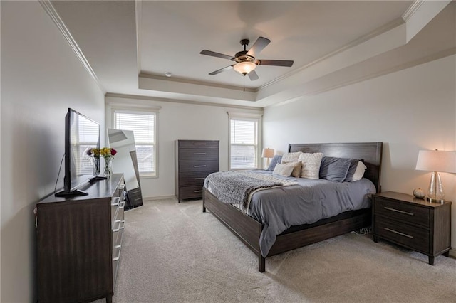 carpeted bedroom featuring crown molding, multiple windows, a raised ceiling, and ceiling fan