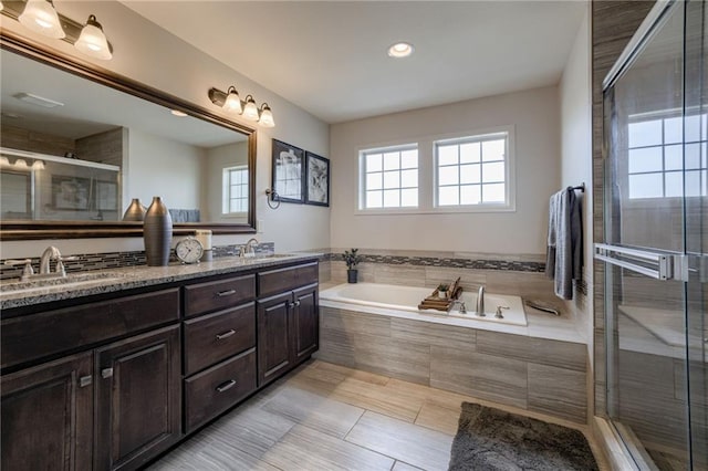 bathroom with shower with separate bathtub and vanity