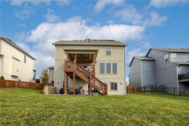 rear view of property with a lawn and ceiling fan