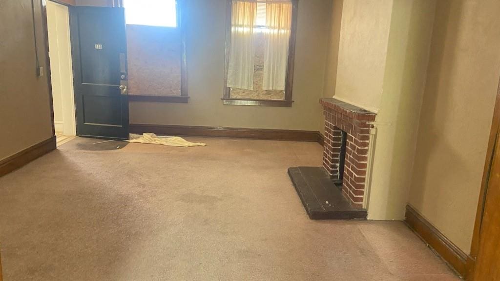 unfurnished living room featuring a fireplace and carpet