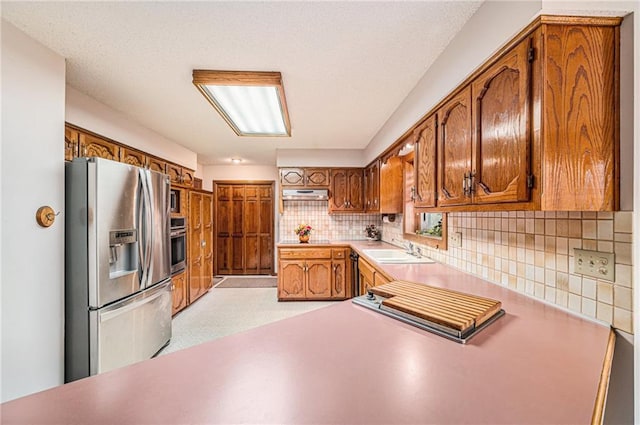 kitchen with sink, stainless steel appliances, and backsplash