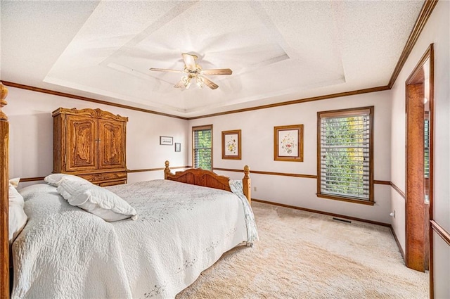 bedroom with multiple windows, a textured ceiling, a raised ceiling, and ceiling fan